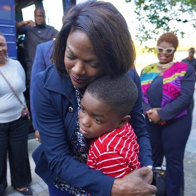 Val Demings is hugging the kid while the people are looking on.